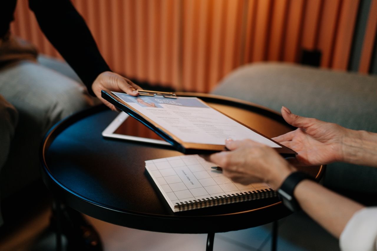 The Art of Drawing Readers In: Your attractive post title goes here Business professionals exchanging resume during meeting, focusing on career advancement.